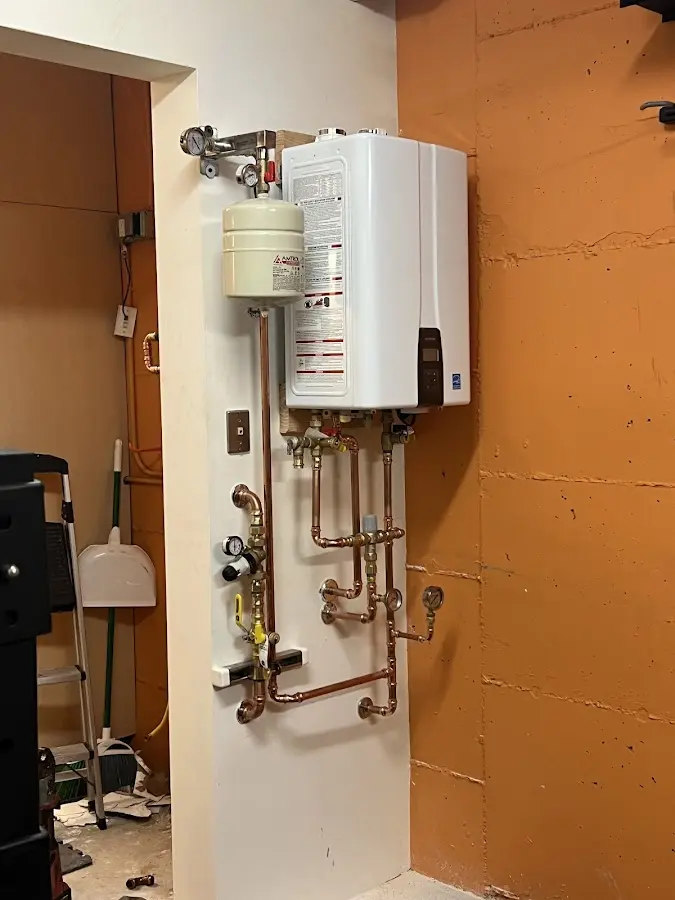 Plumbing technician inspecting water heater connections in Plains